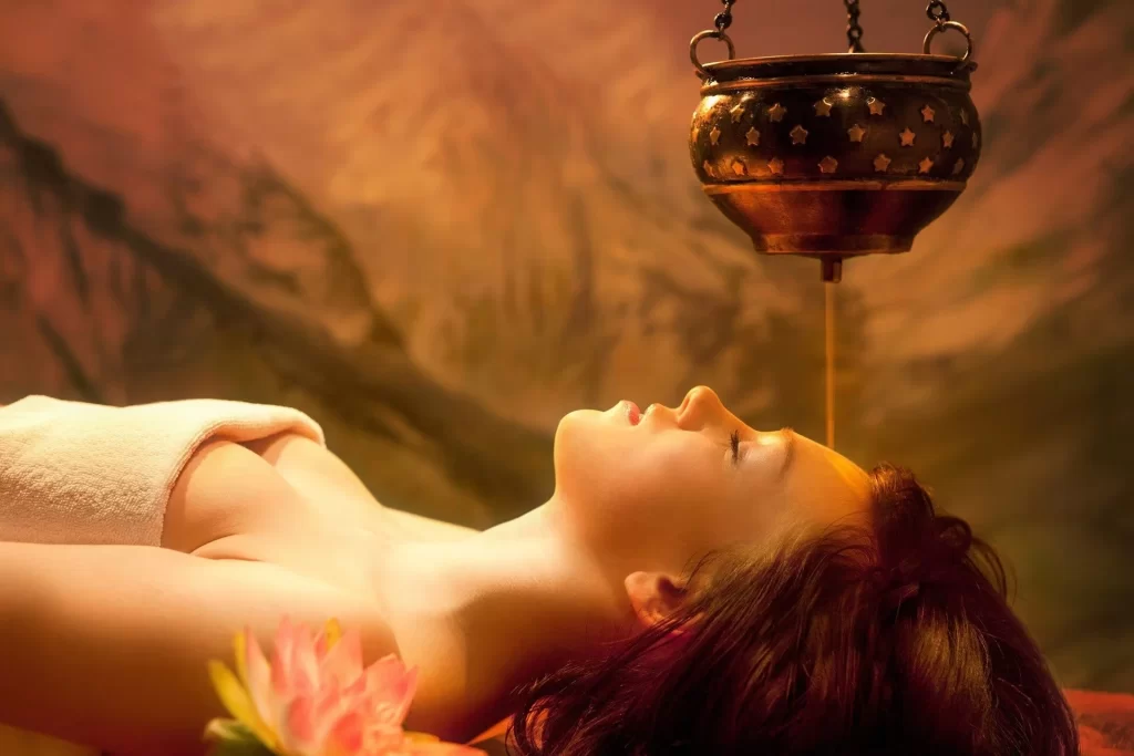Shirodhara therapy using a traditional vessel to pour liquid over the forehead